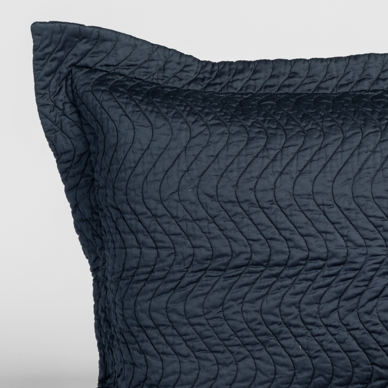 Cirillo Throw Pillow | Slate | close-up of a cirillo sham corner in slate, a polished dusky dark blue, against a plain white background.