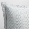 Cirillo Throw Pillow | Cloud | a close up of a pillow corner showing the flange framing quilted cotton sateen shot against a white background.