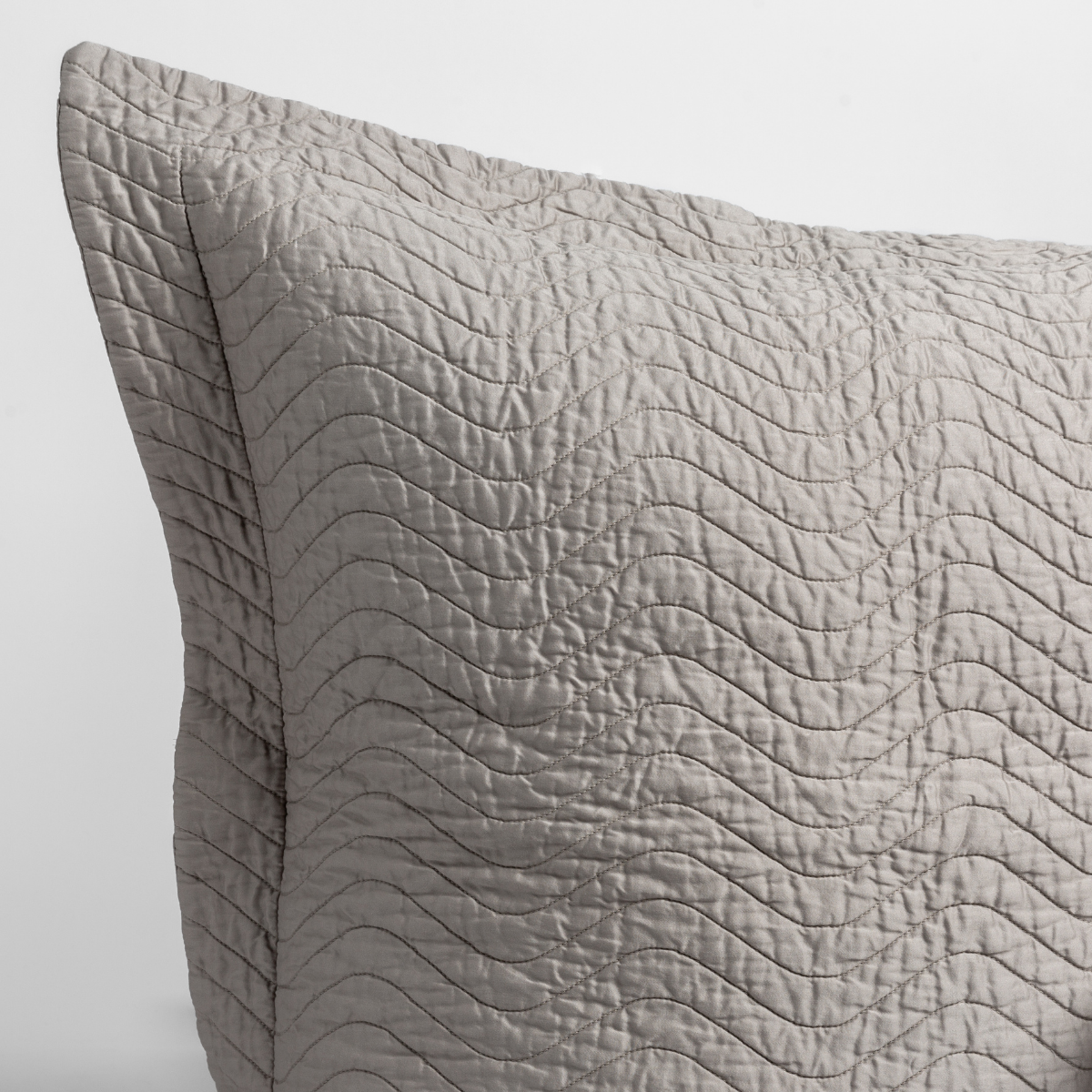 Cirillo Throw Pillow | Fog | a close up of a pillow corner showing the flange framing quilted cotton sateen shot against a white background.
