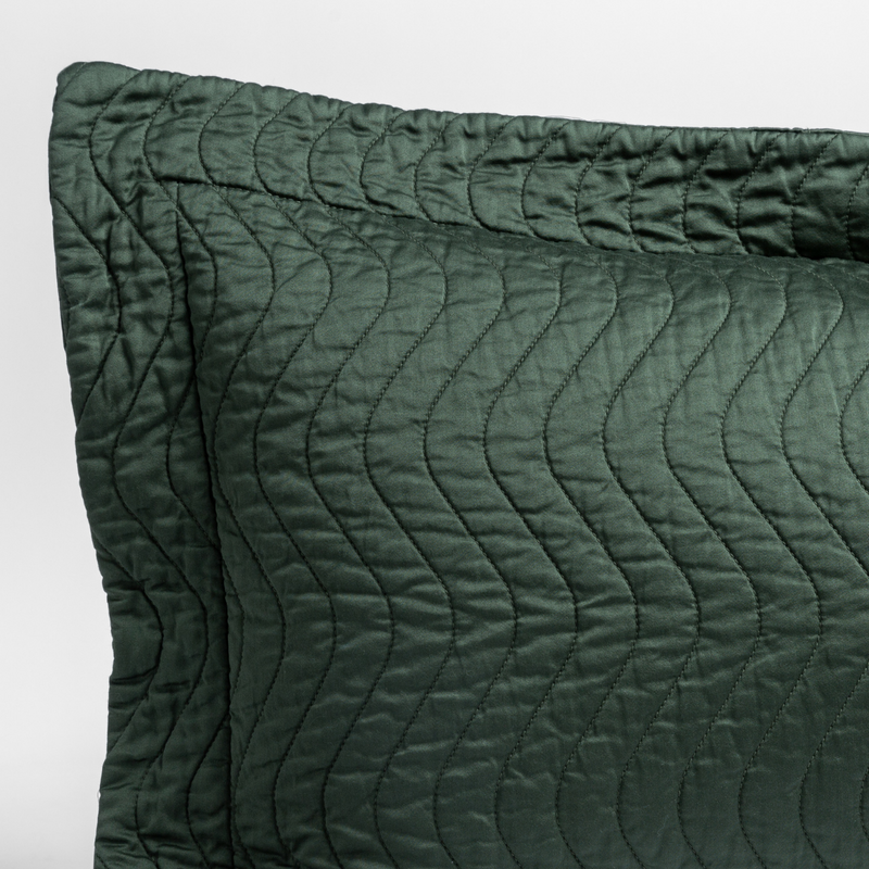 Cirillo Throw Pillow | Juniper | a close up of a pillow corner showing the flange framing quilted cotton sateen shot against a white background.