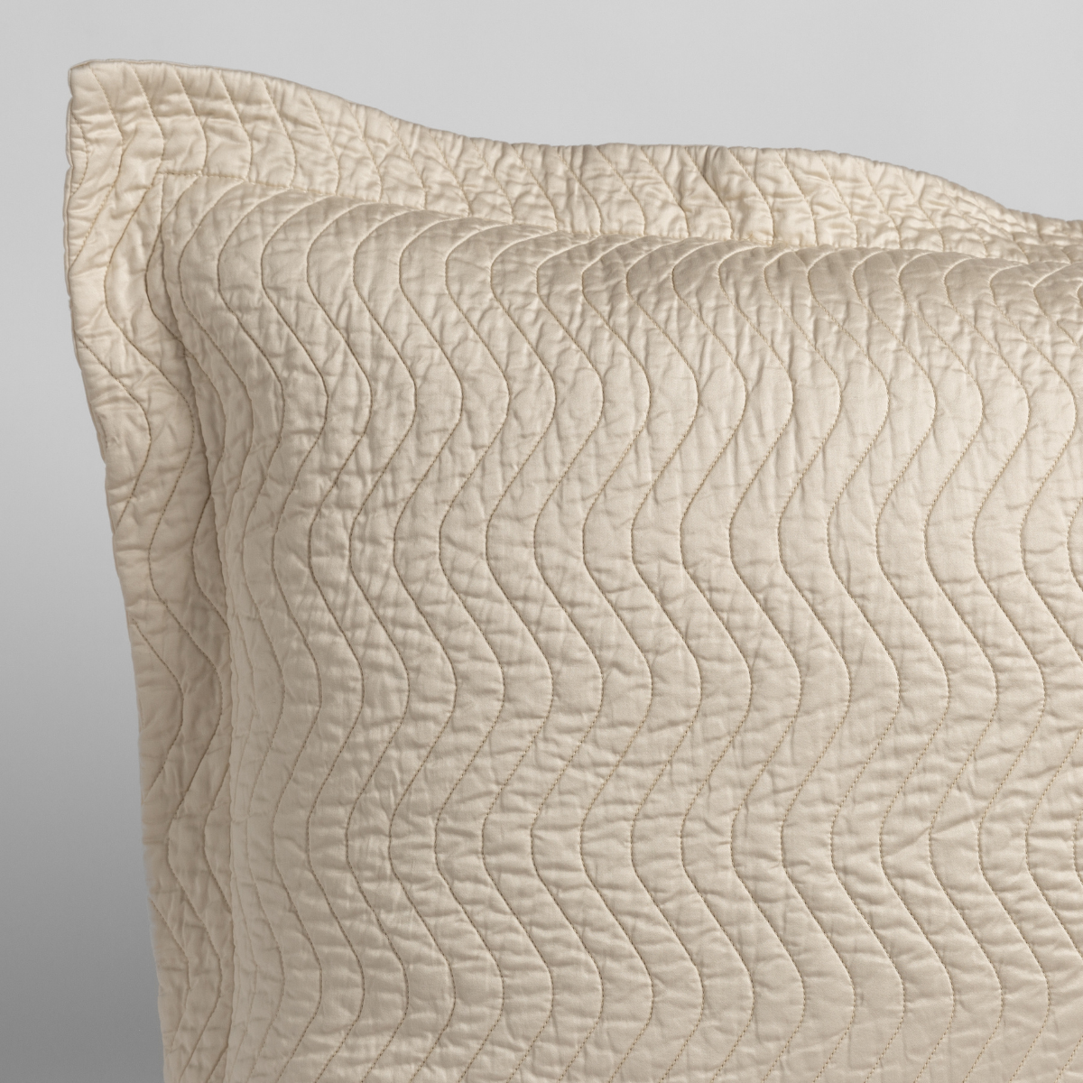 Cirillo Throw Pillow | Parchment | a close up of a pillow corner showing the flange framing quilted cotton sateen shot against a white background.