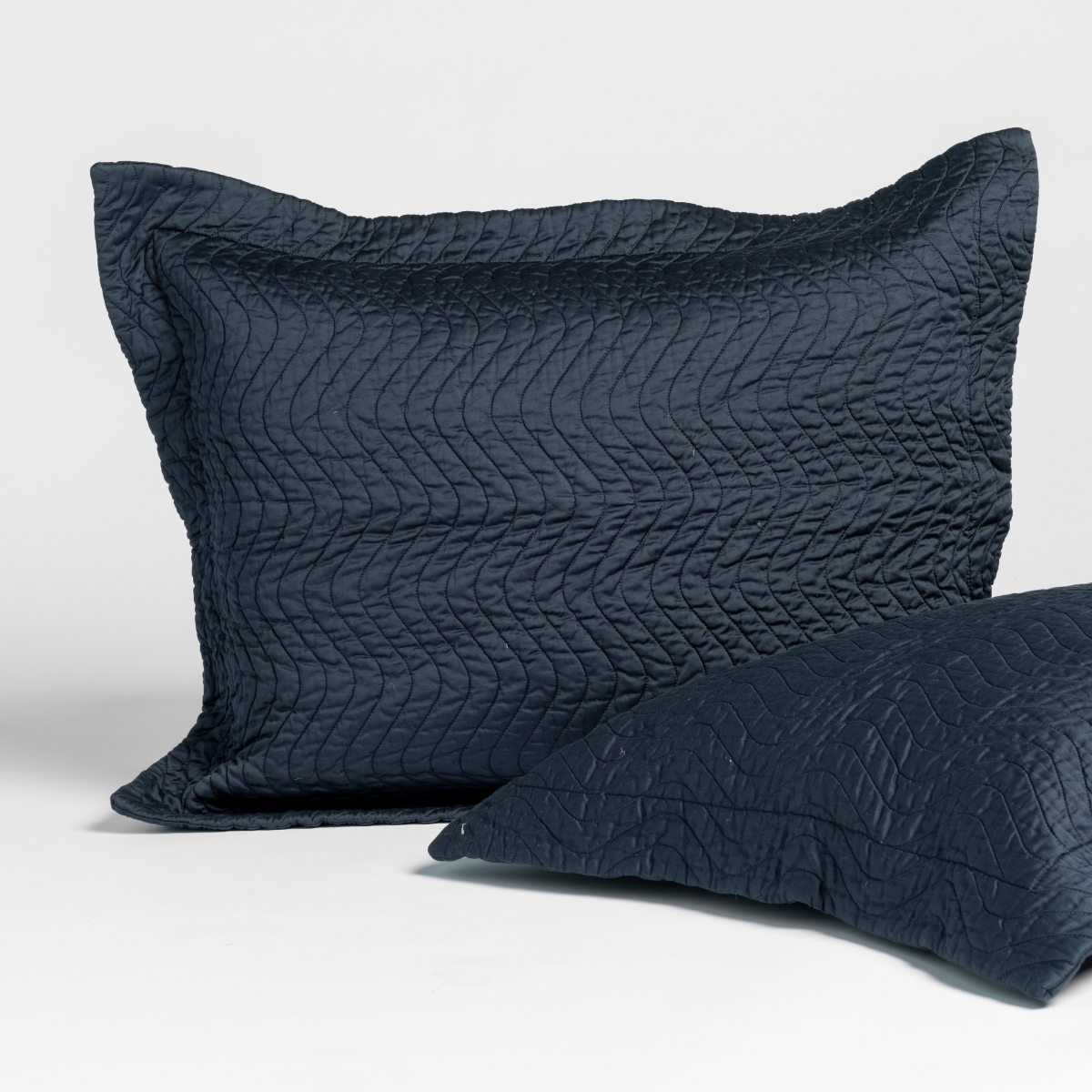 Slate | matching pair of cirillo shams in slate, a polished dusky dark blue, shown against a white background.