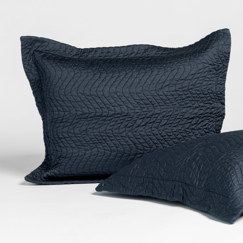 Slate | matching pair of cirillo shams in slate, a polished dusky dark blue, shown against a white background.