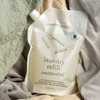 a refill pouch of unscented common good laundry detergent nested in linen and cotton fabrics in various colors.