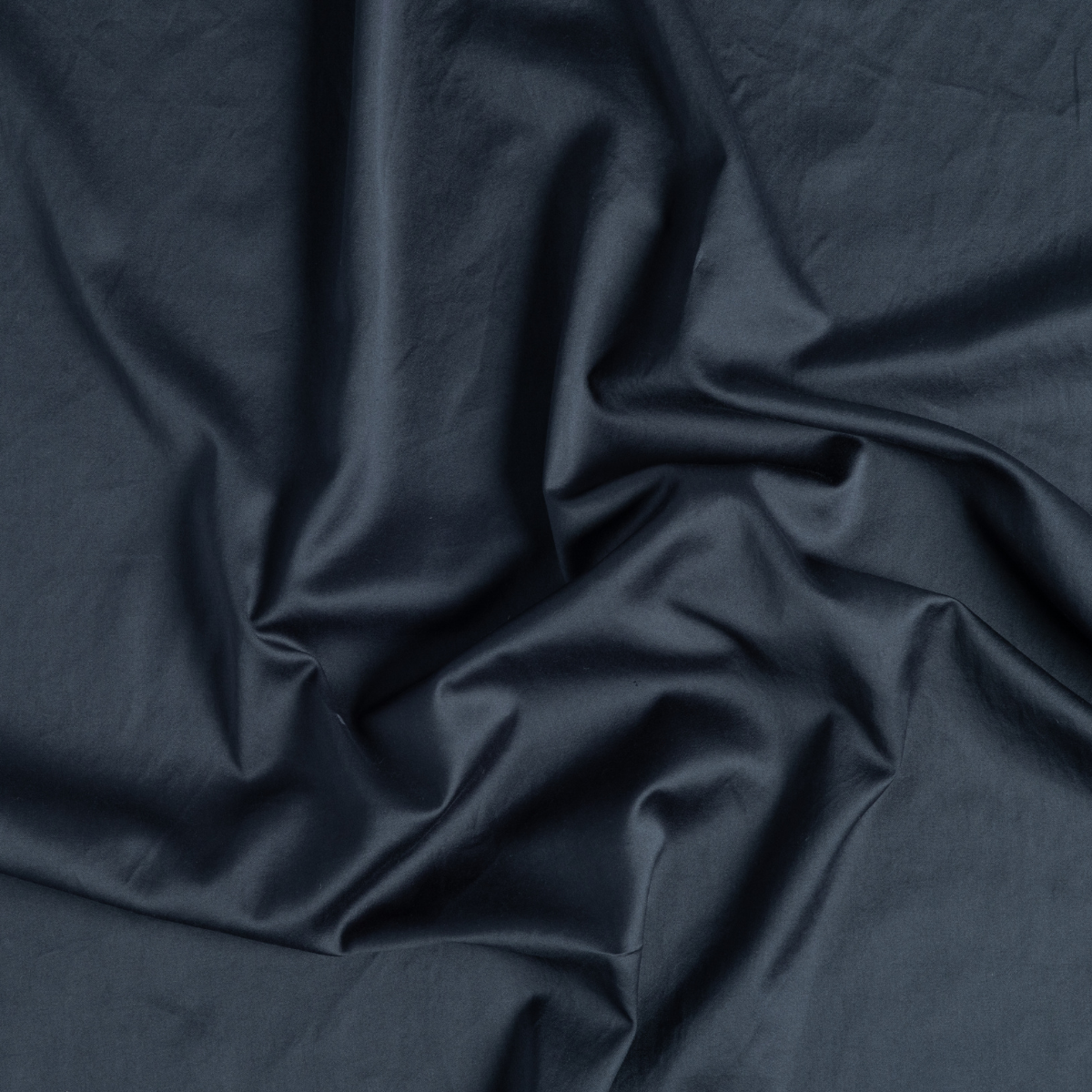 Bria Standard Pillowcase (Single) | Slate | a close-up of gently swirled cotton sateen fabric in slate, a polished dusky dark blue