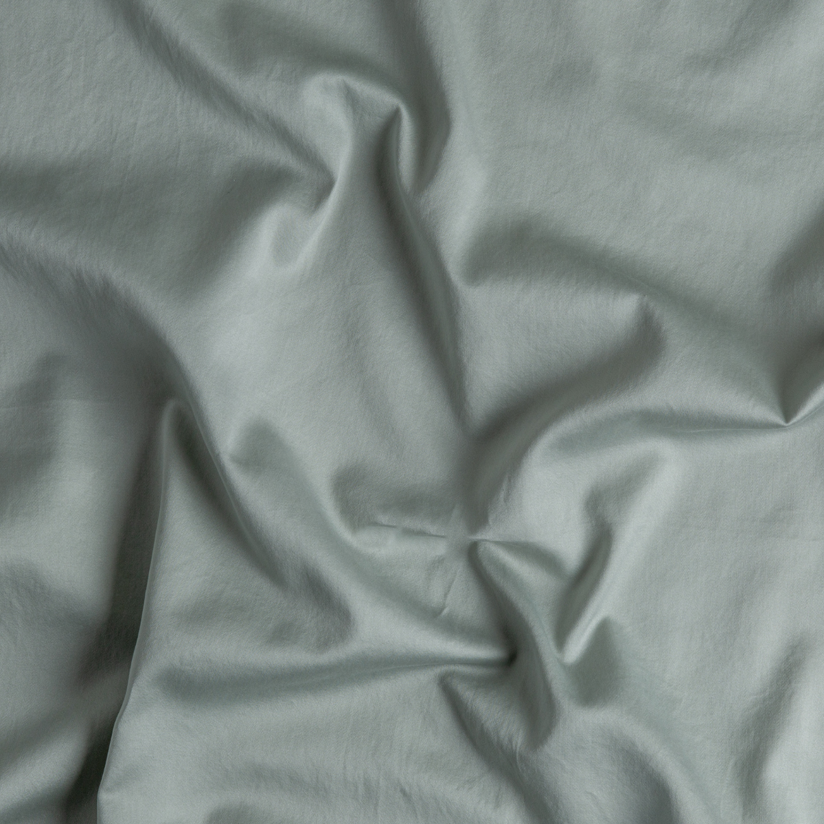 Bria Twin Flat Sheet | Eucalyptus | A close up of cotton sateen fabric in eucalyptus, a soft light green.
