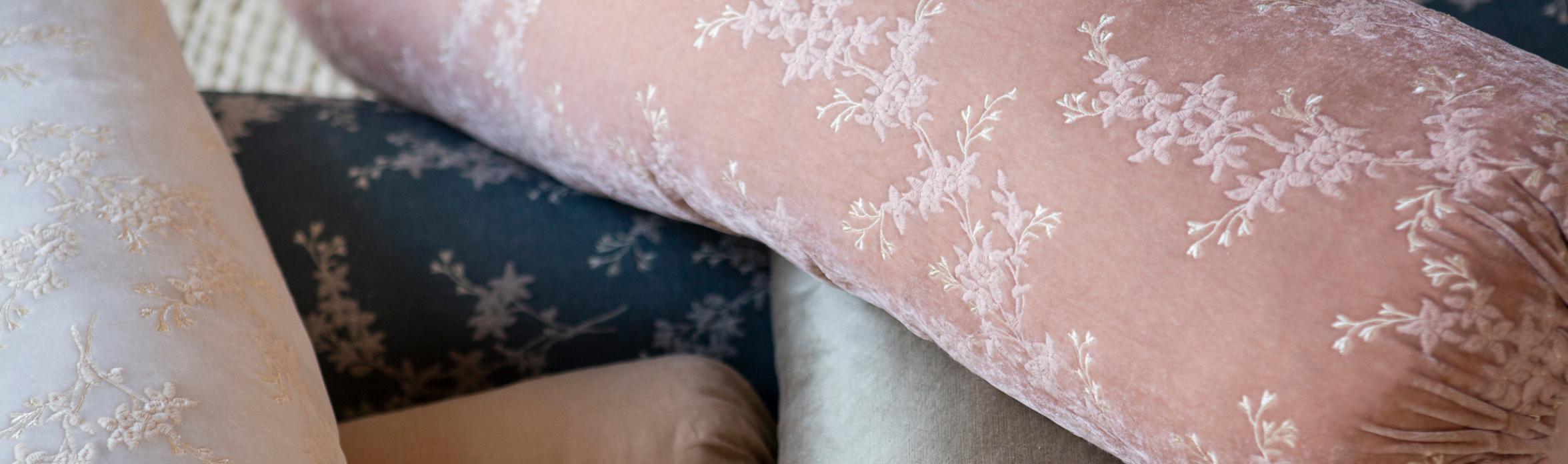 Up-close picture of a floral embroidered fabric in a light pink color 