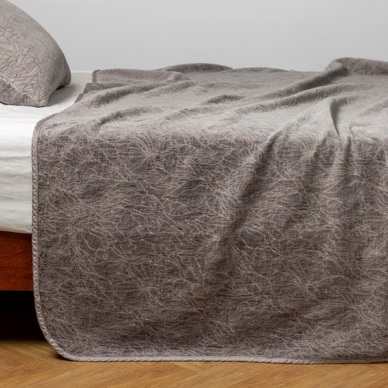 Georgia Bedspread | Moonlight | side view of the chenille jacquard side of a bedspread with the cotton jacquard side showing on the matching sham — shown with a winter white fitted sheet.