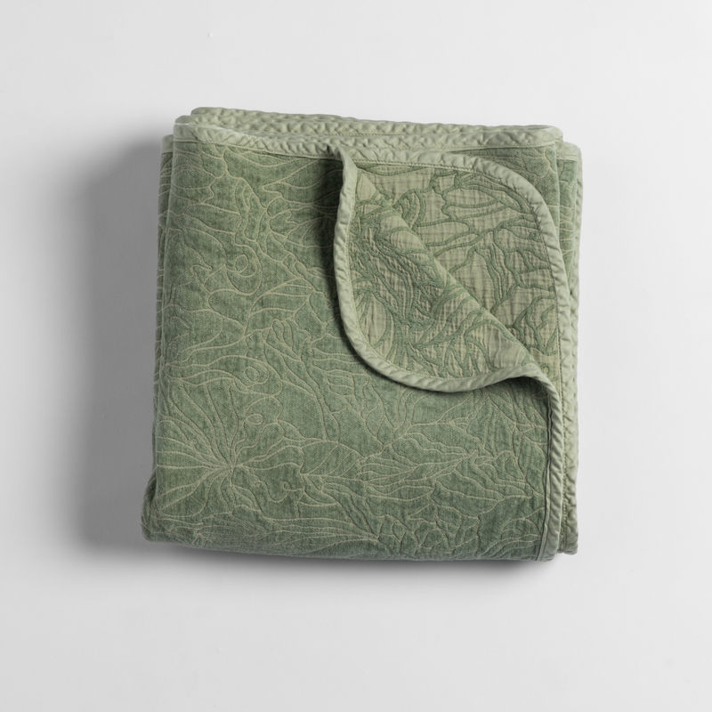 Georgia Blanket | Desert Sage | an overhead shot of a folded blanket in desert sage, a serenely elegant green, offering a hushed hue, shown against a plain background.