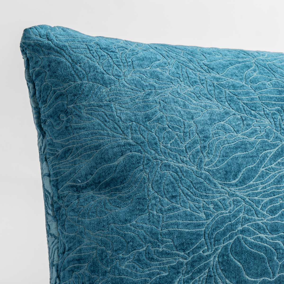 Georgia Throw Pillow | Cenote | close up of the chenille jacquard corner of a pillow cushion with a single-line floral pattern.