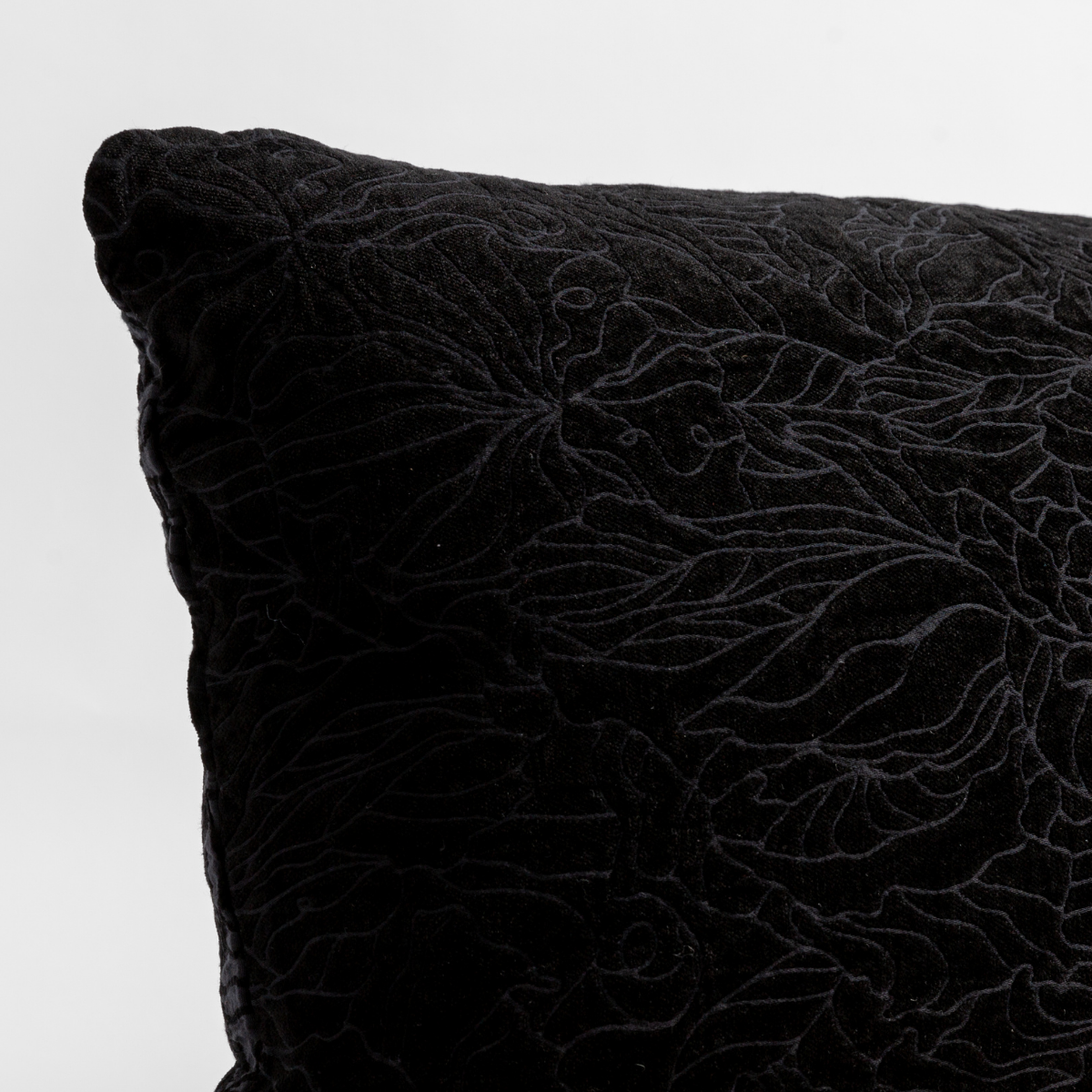 Georgia Throw Pillow | Corvino | close up of the chenille jacquard corner of a pillow cushion with a single-line floral pattern.