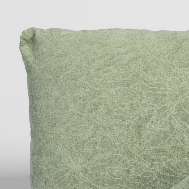 Georgia Throw Pillow | Desert Sage | close up of a pillow corner in desert sage, a serenely elegant green, offering a hushed hue, shown against a plain background.