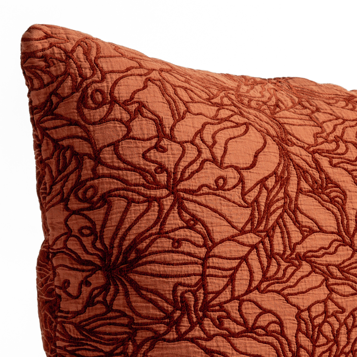 Georgia Throw Pillow | Autumn | A close-up of the corner of a Georgia cushion with the cotton jacquard side in Autumn, a rich terracotta tone, shown against a white background.