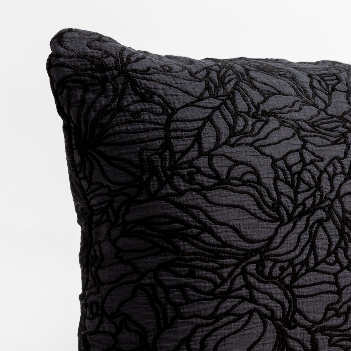 Georgia Throw Pillow | Corvino | close up of the cotton jacquard corner of a pillow cushion with a single-line floral pattern.