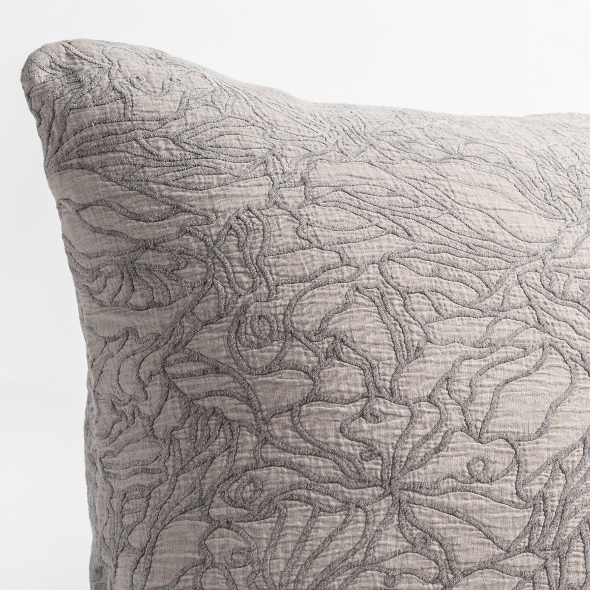 Georgia Throw Pillow | Moonlight | close up of the cotton jacquard corner of a pillow cushion with a single-line floral pattern.