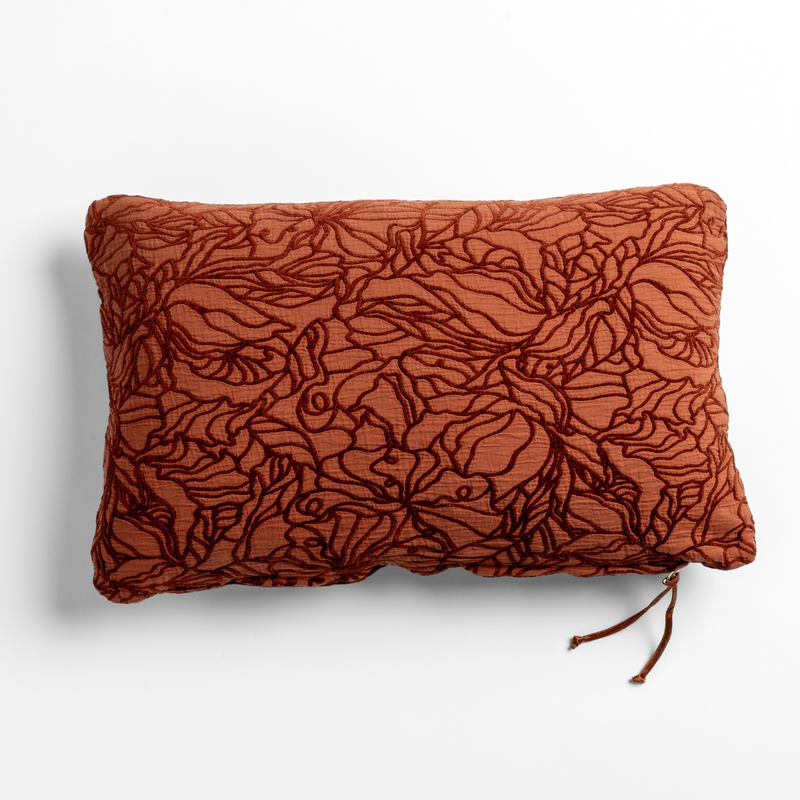 Autumn | A close-up of a cotton jacquard side of a Georgia Throw Pillow in Autumn, a rich terracotta tone, shown against a white background.