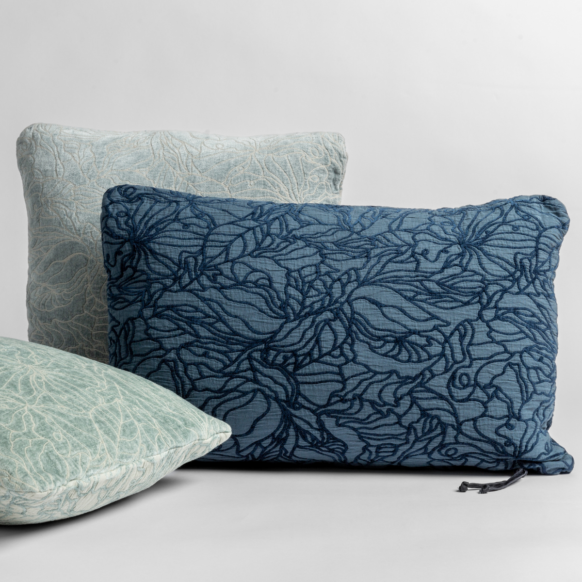 Georgia Throw Pillow | throw pillows in different sizes and shapes shown in green and blue tones, the different sides of the pillow show the tonal and pattern contrast.
