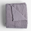 Ines Blanket | French Lavender | folded midweight linen blanket with corner folded back, shot overhead against a white background.