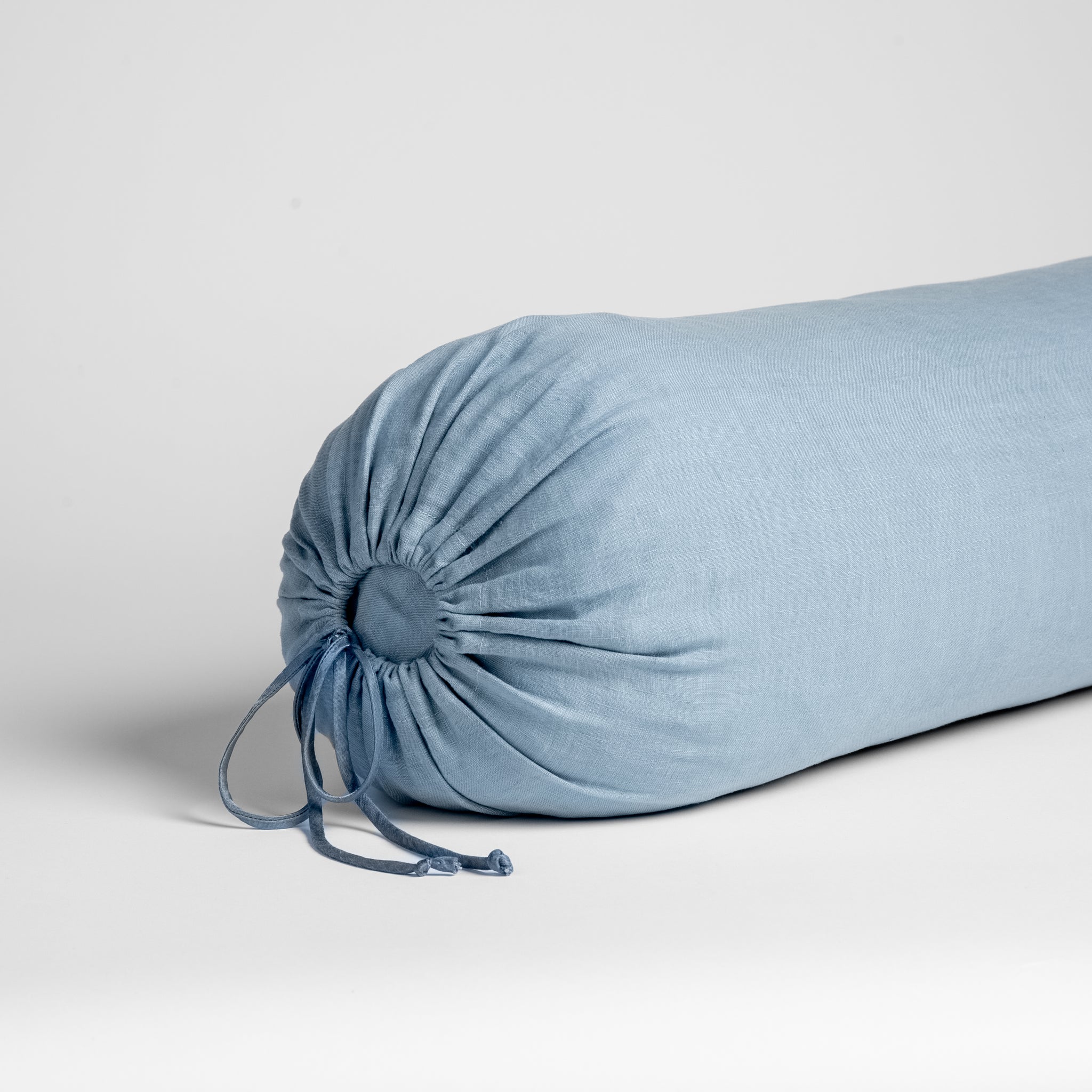 Linen Throw Pillow | Tahoe Blue | Close-up of Linen bolster end detail in Tahoe Blue, angled to show gathering and satin ties.