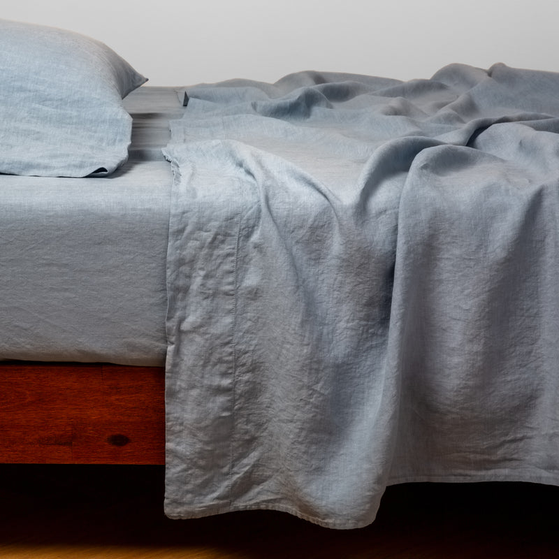 Linen Fitted Sheet | Tahoe Blue | fitted sheet with matching rumpled flat sheet and sleeping pillow - side view.