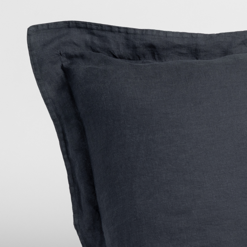 Slate | close-up of a linen sham corner in slate, a polished dusky dark blue, against a plain white background.