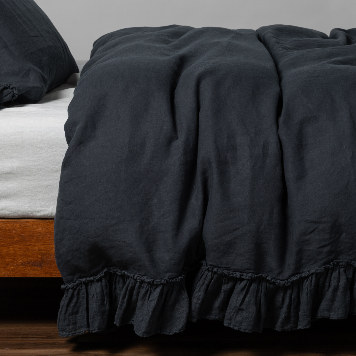 Linen Whisper Duvet Cover | Slate | linen with whisperweight linen ruffle duvet cover with matching sham shown from the side on a bed against aa white background.