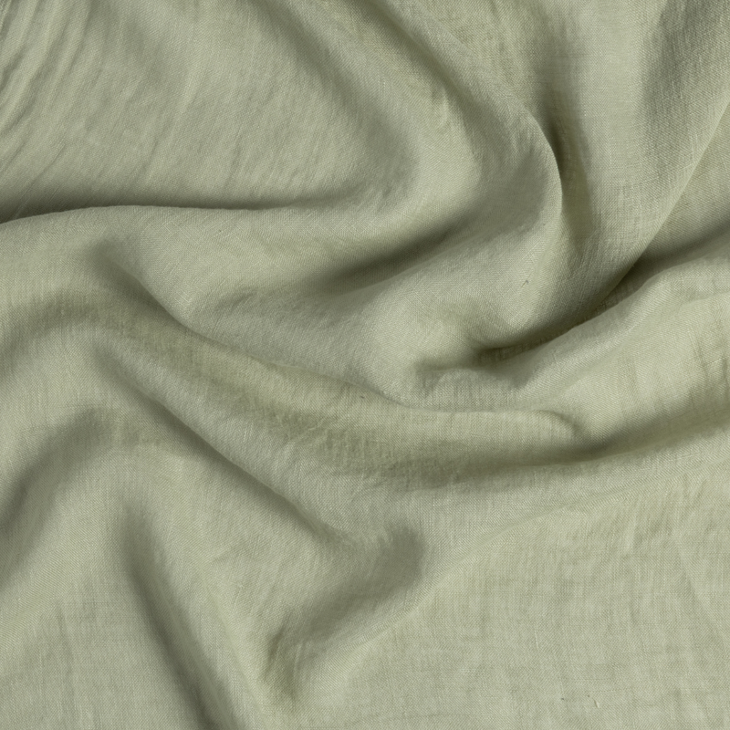 Linen Whisper Bed Skirt | Desert Sage | close-up of whisperweight linen fabric gently rumpled in desert sage, a serenely elegant green, offering a hushed hue.