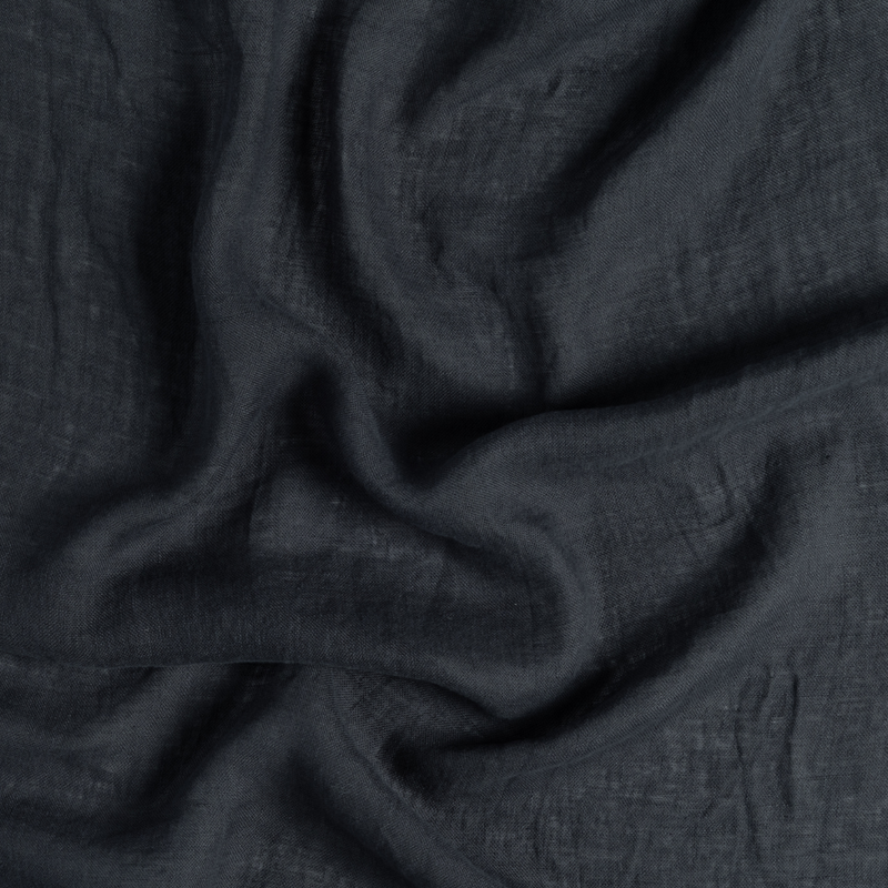 Linen Whisper Bed Skirt | Slate | a close-up of gently swirled lightweight linen fabric in slate, a polished dusky dark blue
