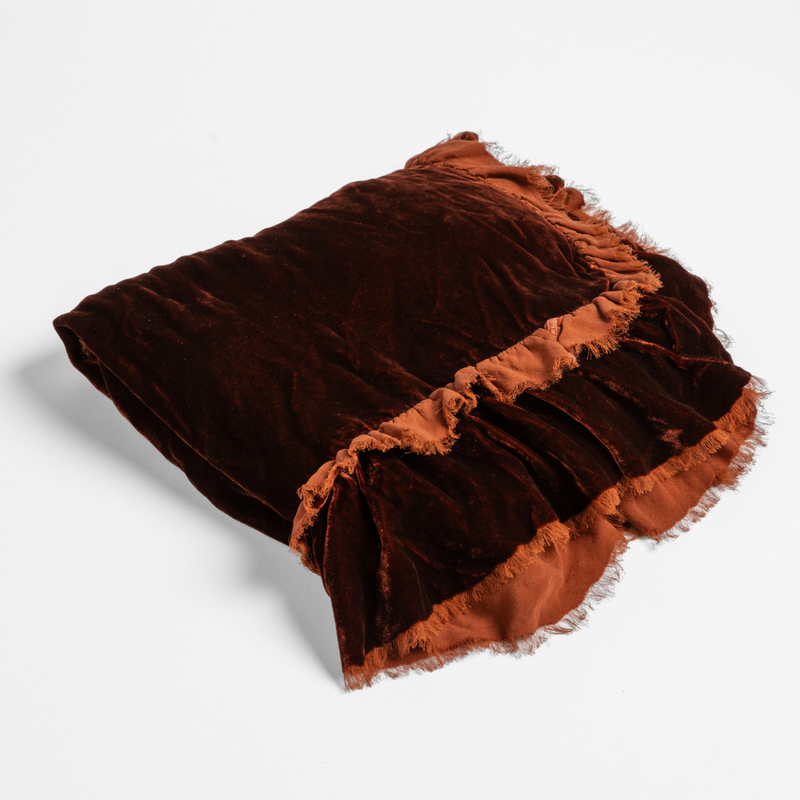 Autumn | A close-up of the corner of a folded Loulah Baby Blanket in Autumn, a rich terracotta tone, shown against a white background.