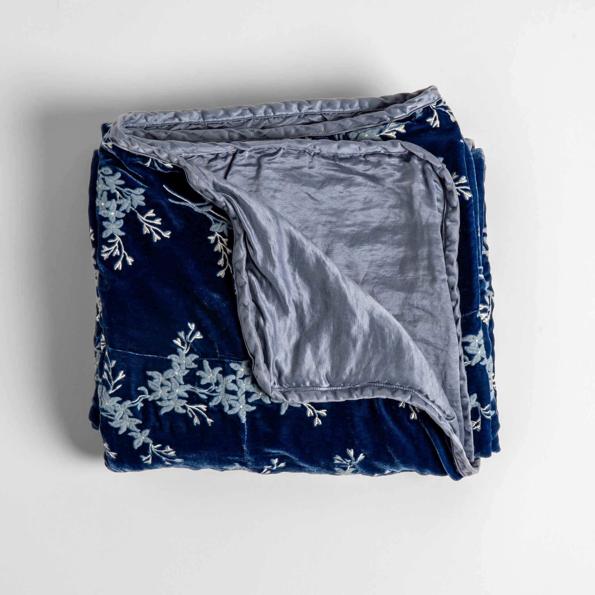 Lynette Blanket | Tahoe Blue | overhead angle of the folded blanket with a corner pulled back to show the reverse and trim.
