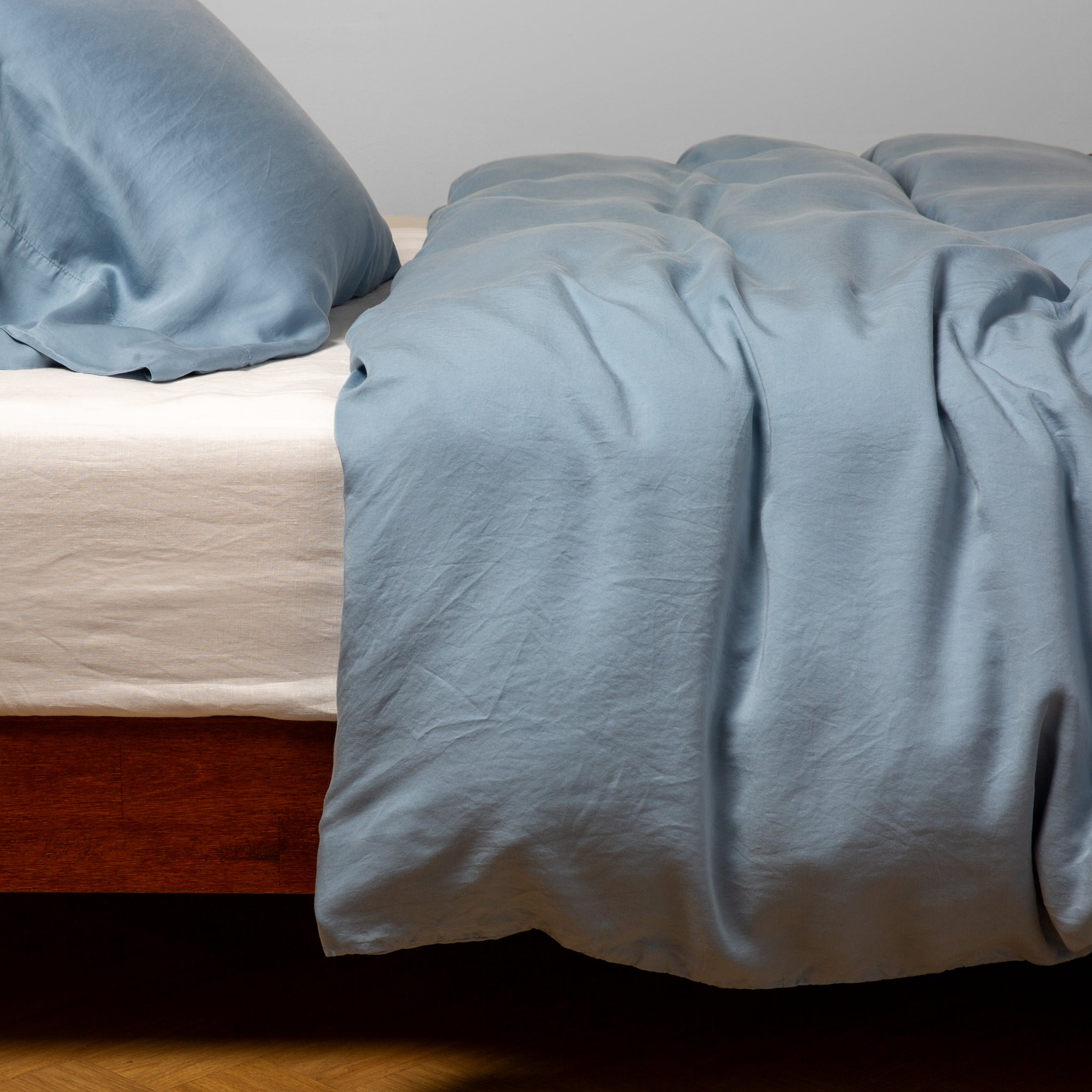 Madera Luxe Duvet Cover | Tahoe Blue | duvet cover with matching sleeping pillow and fitted sheet - side view.