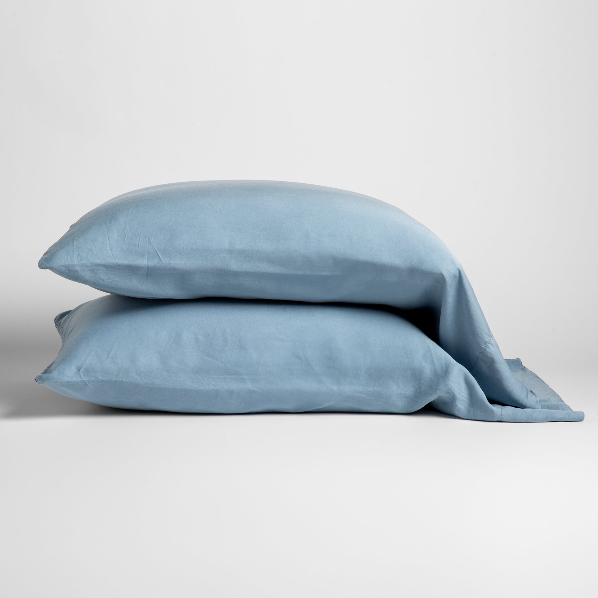Madera Luxe Pillowcase (Single) | Tahoe Blue | sleeping pillows stacked neatly against a white backdrop - side view.