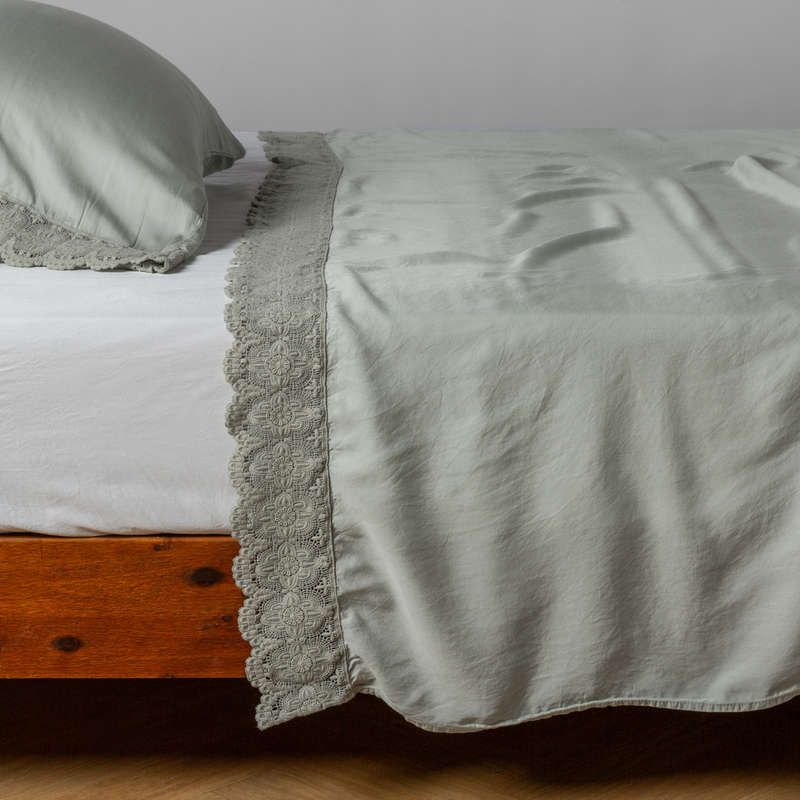 Madera Luxe Flat Sheet | Eucalyptus | matching tencel flat sheet and pillowcase with cotton lace trim on a bed shown from the side