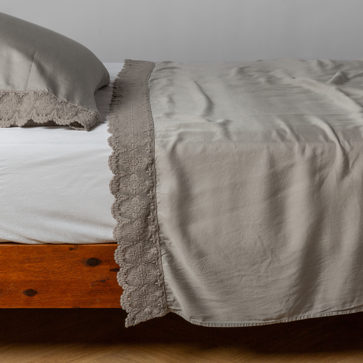 Madera Luxe Flat Sheet | Fog | matching tencel flat sheet and pillowcase with cotton lace trim on a bed shown from the side