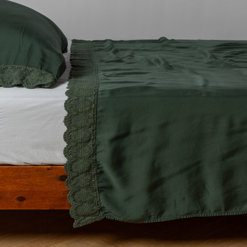 Madera Luxe Flat Sheet | Juniper | matching tencel flat sheet and pillowcase with cotton lace trim on a bed shown from the side