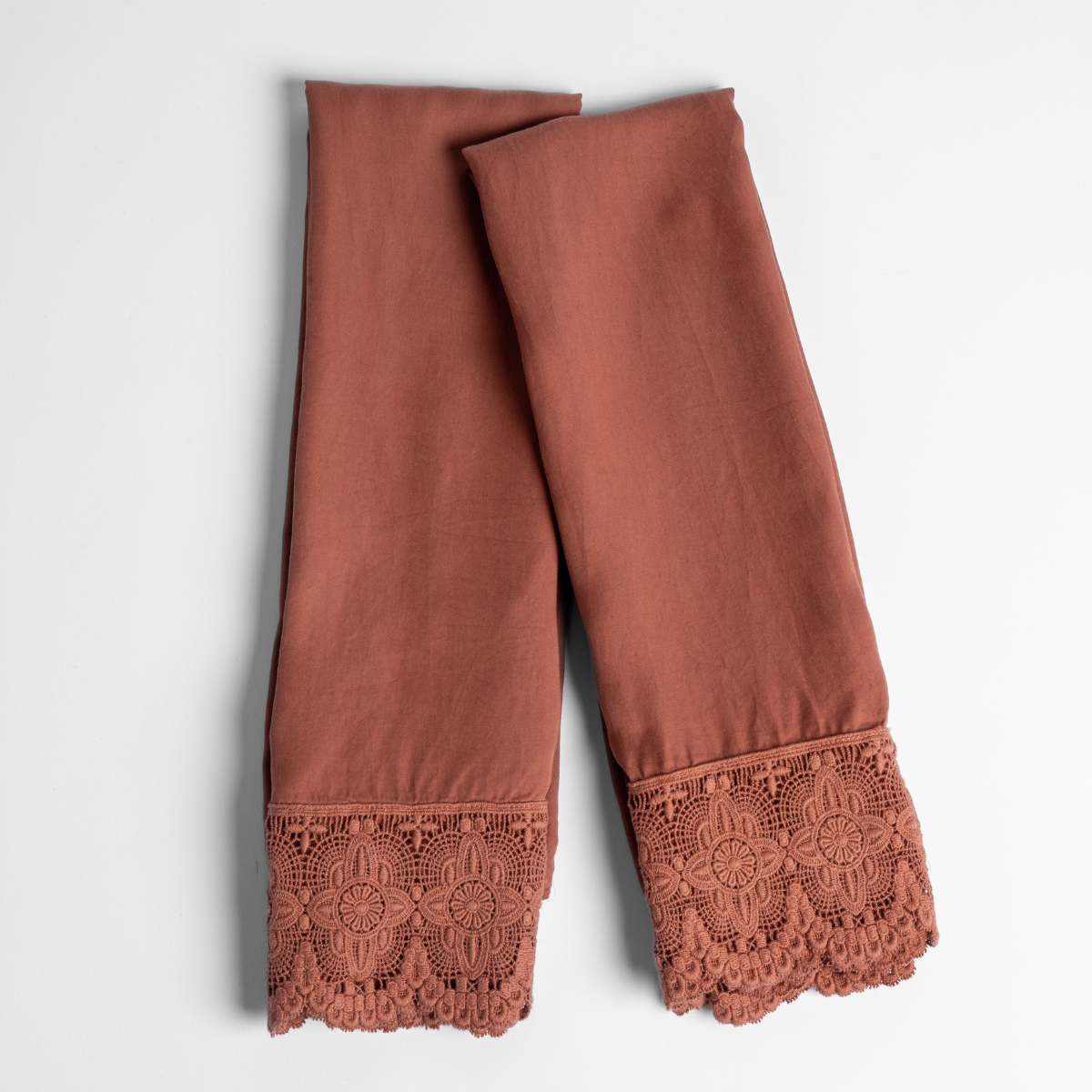 Madera Luxe Pillowcase (Single) | Autumn | A pair of folded Madera Luxe Donella pillowcases without inserts in Autumn, a rich terracotta tone, shown against a white background.