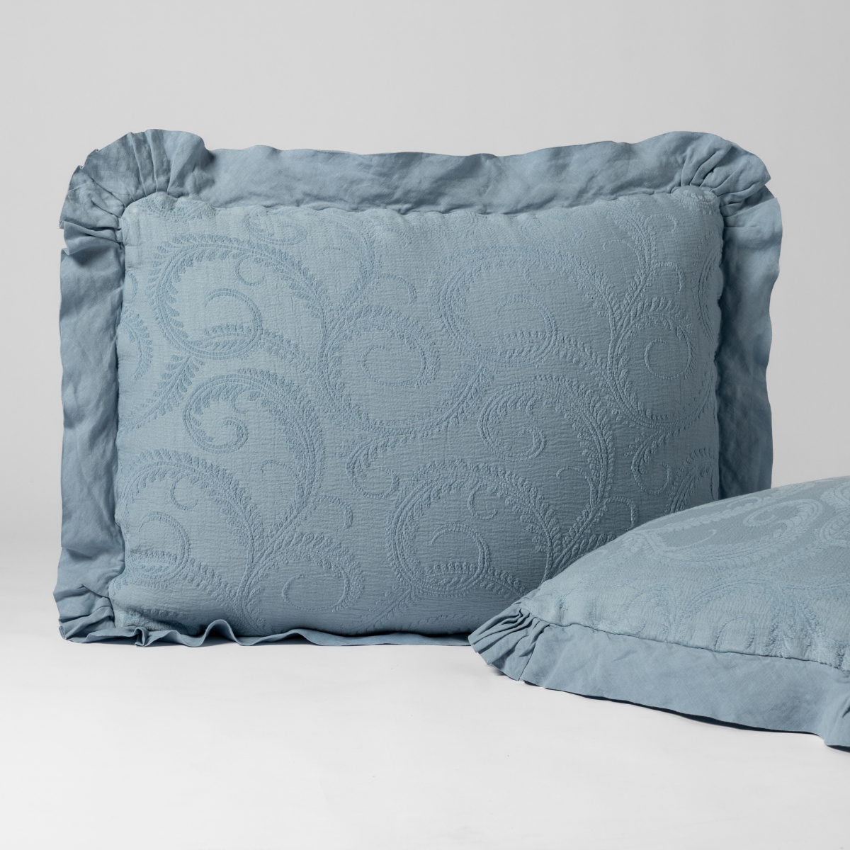 Marisette Sham | Tahoe Blue | a matching pair of organic cotton damask shams, one upright and one on its side shown against a white background.