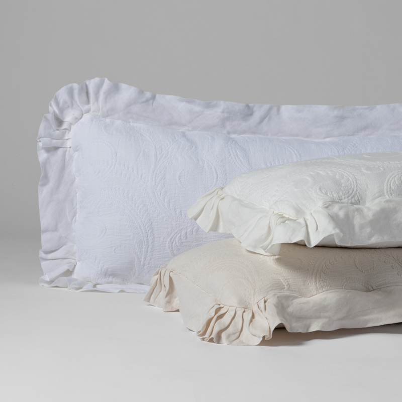 Marisette Throw Pillow | organic cotton damask with linen trimmed 16x36-inch throw pillows in White, Winter White and Natural against a plain background.