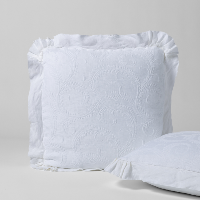 Marisette Sham | White | a matching pair of organic cotton damask shams, one upright and one on its side against a plain background.