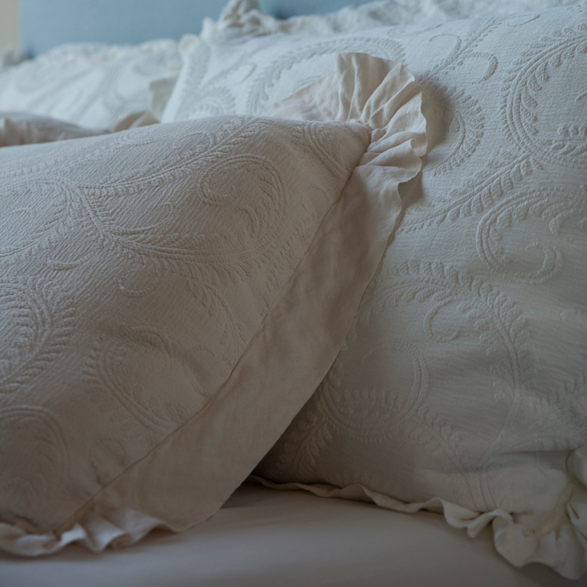Marisette Sham | a close-up of organic cotton damask shams showing the swirling pattern and linen ruffle
