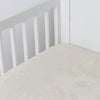 Mirabella Baby Bundle - Holiday Release | Parchment | silk and tencel™ blend jacquard crib sheet shot from above at a slight angle into the corner of a white crib.