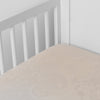 Mirabella Baby Bundle - Holiday Release | Pearl | silk and tencel™ blend jacquard crib sheet shot from above at a slight angle into the corner of a white crib.