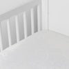 Mirabella Baby Bundle - Holiday Release | White | silk and tencel™ blend jacquard crib sheet shot from above at a slight angle into the corner of a white crib.