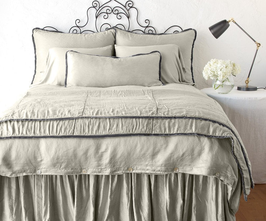 Fog: throw blanket folded at the end of a monochromatic, charmeuse bed - end of bed view.