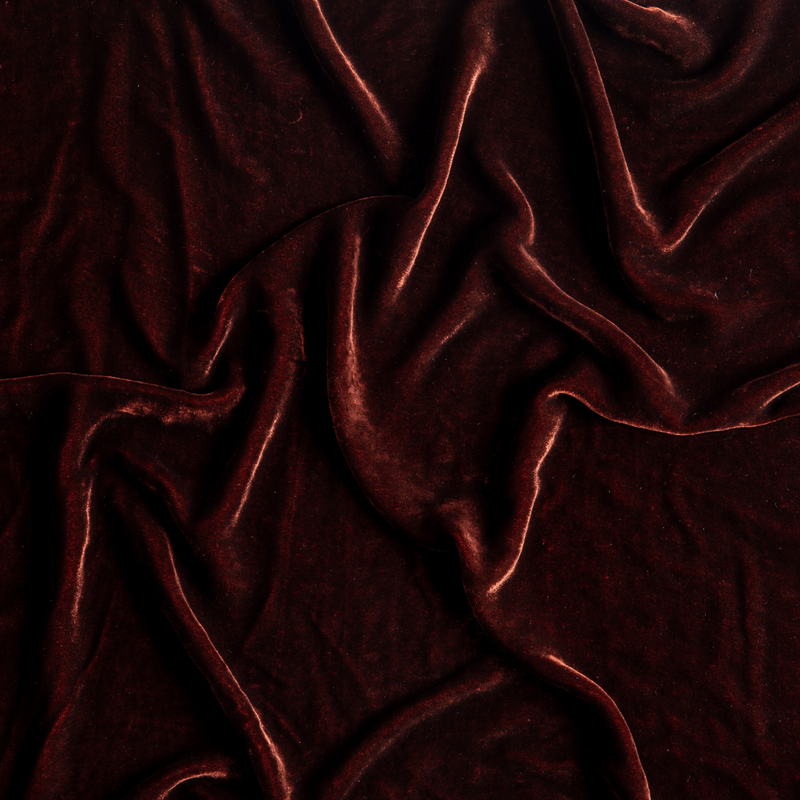 Loulah Baby Blanket | Autumn | A close-up of Silk Velvet fabric gently rumpled in the colorway, Autumn, a rich terracotta tone.