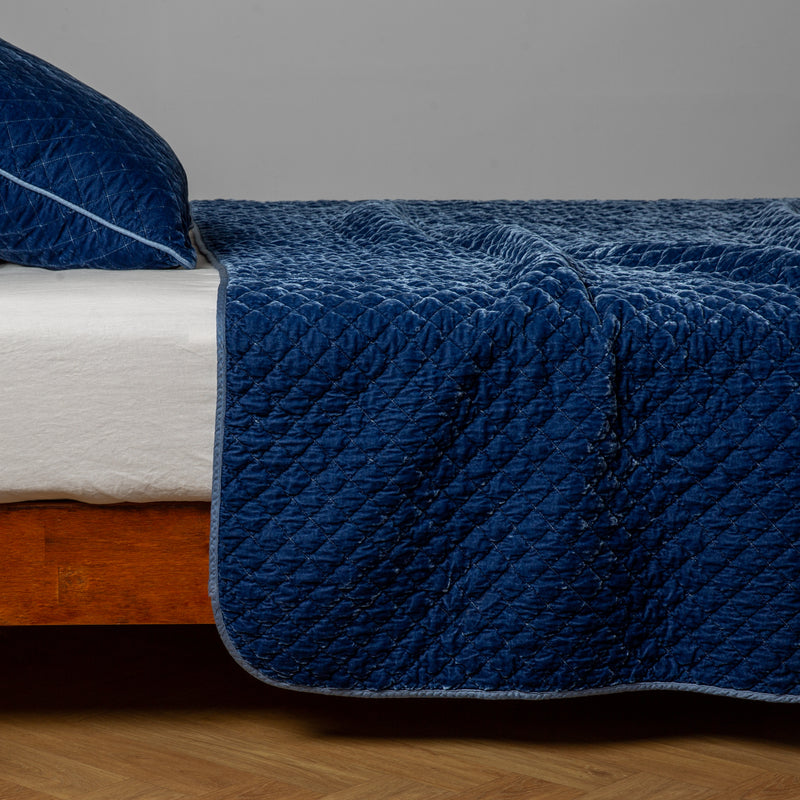 Silk Velvet Quilted Coverlet | Tahoe Blue | A side view of a Tahoe Blue throw blanket with matching sham; Tahoe Blue is a saturated blue like a crystal clear sky.