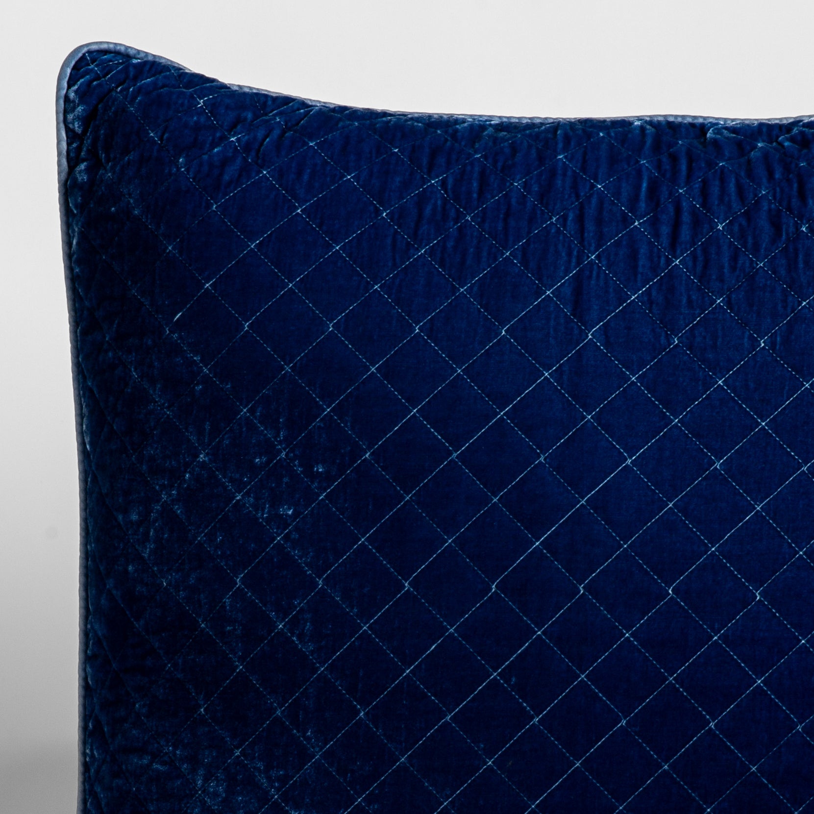 Silk Velvet Quilted Sham | Tahoe Blue | A close-up of a corner of a Silk Velvet Quilted Throw Pillow in Tahoe Blue, a saturated blue like a crystal clear sky, shown against a white background. 