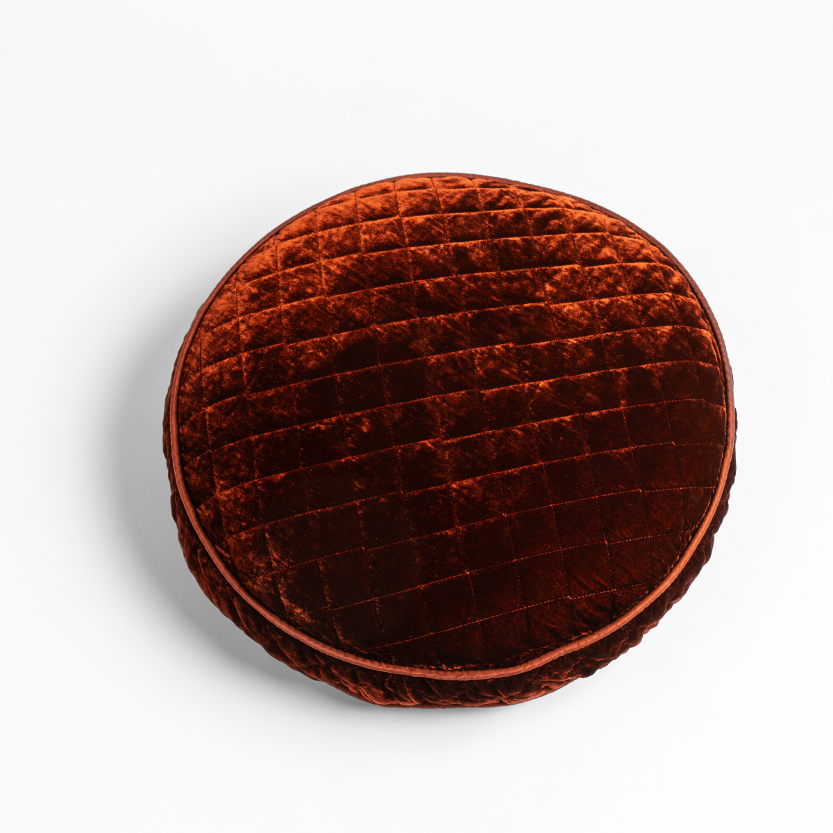 Silk Velvet Quilted Throw Pillow | Autumn | A close-up of a Silk Velvet Quilted Round Throw Pillow in Autumn, a rich terracotta tone, shown against a white background.