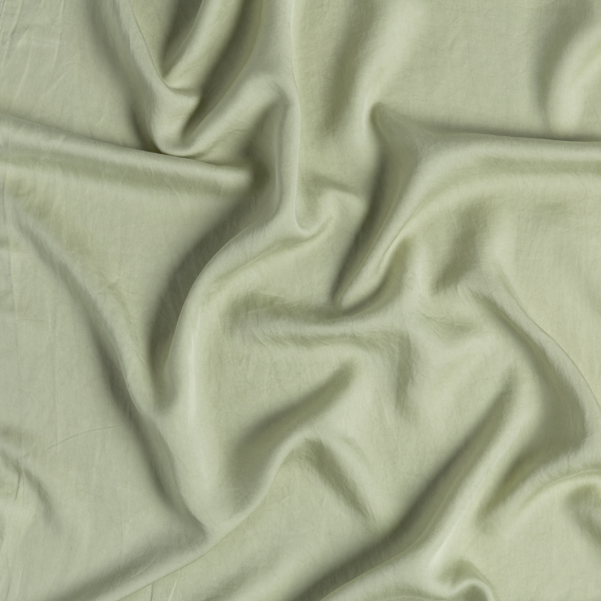 Madera Luxe Twin Fitted Sheets | Desert Sage | close-up of tencel fabric gently rumpled in desert sage, a serenely elegant green, offering a hushed hue.