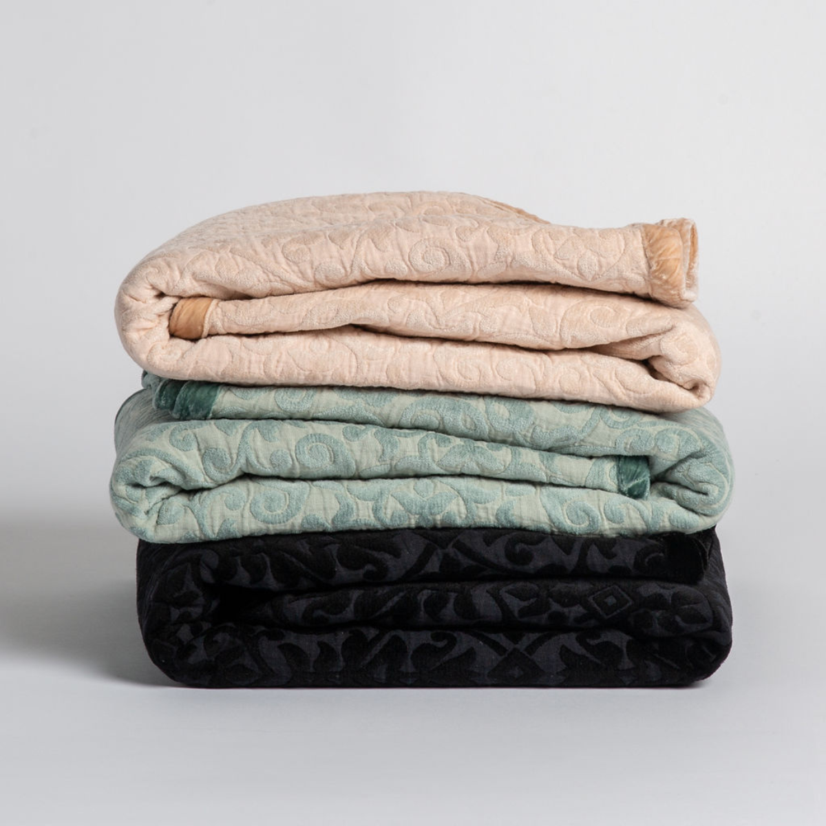 Vienna Blanket | A stack of three cotton jacquard throw blankets against a white background.